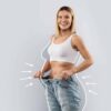 Woman in a sports bra holding out the waistband of loose jeans, with illustrated arrows and outline indicating weight loss and body contouring results