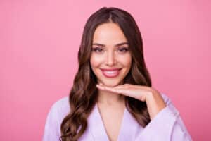 Smiling woman gently framing her beautifully reshaped chin with her hand