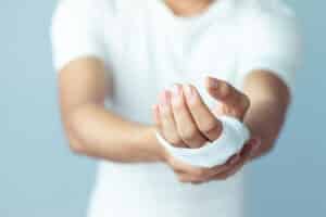 Man holding up injured hand that's been medically wrapped