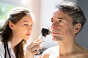 Dermatologist examining man's face for skin cancer