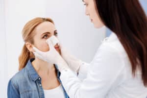 Plastic surgeon evaluating facial reconstruction options after skin cancer removal