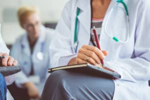 Female doctor making notes during seminar