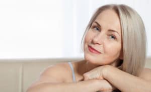Fifty year old woman is very pleased with her well-groomed face. Facelift surgery and collagen injections. Macro face. Selective focus on face. Realistic images with their own imperfections.
