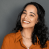 young woman with beautiful smile on grey wall