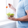 Athletic man eat healthy lunch in modern interior