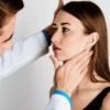 The doctor, a man, put his hand on the patient's neck to assess the severity of the profile