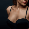 Close up of breast of attractive woman presenting her black bra.