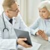 Doctor meeting with older woman and going over plan for nasal skin cancer removal and reconstruction.